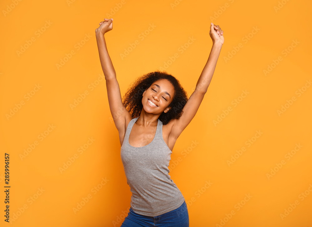 Portrait of happy African-American woman on color background