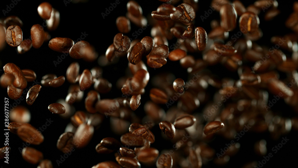 Fresh roasted coffee beans flying in the air