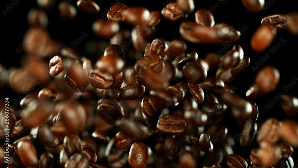 Fresh roasted coffee beans flying in the air