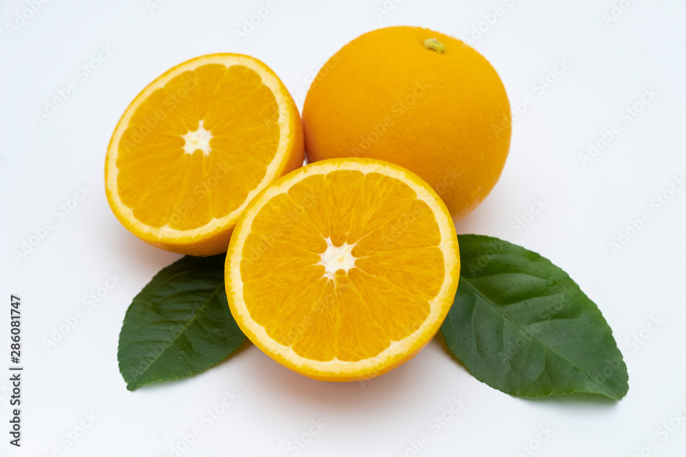 Half of orange and whole with green leaf isolated on white background