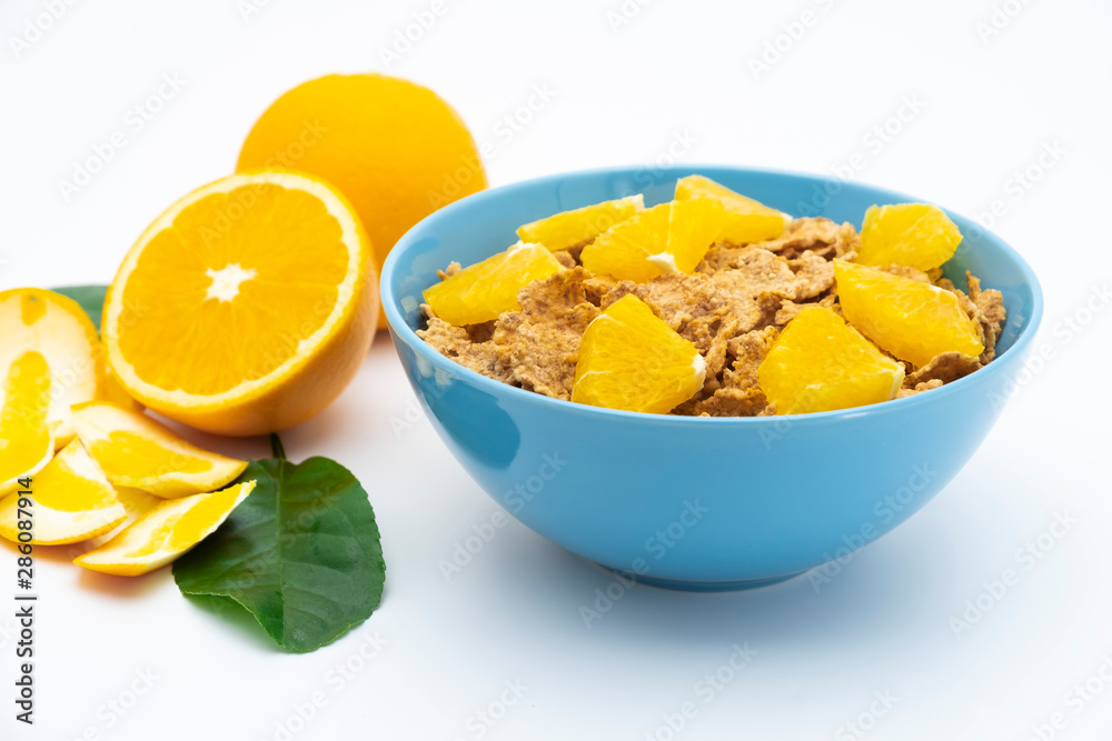 Cereal flake with pieces orange fruits slice in the blue bowl isolated on white background