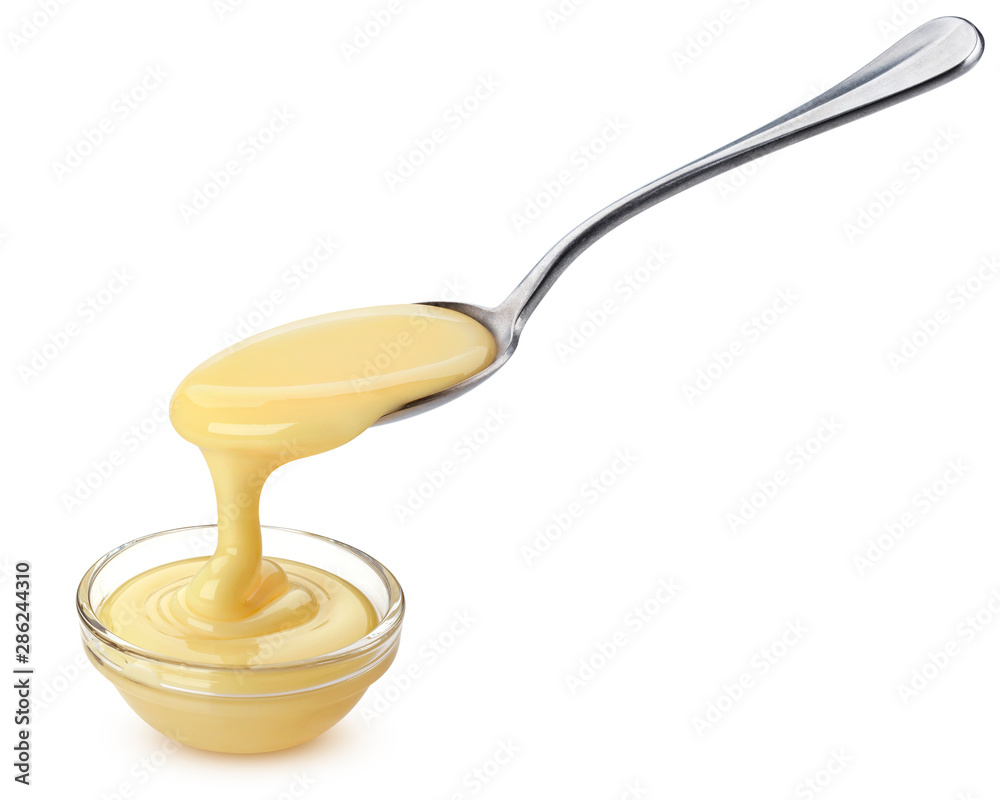 Pouring condensed milk isolated on white background