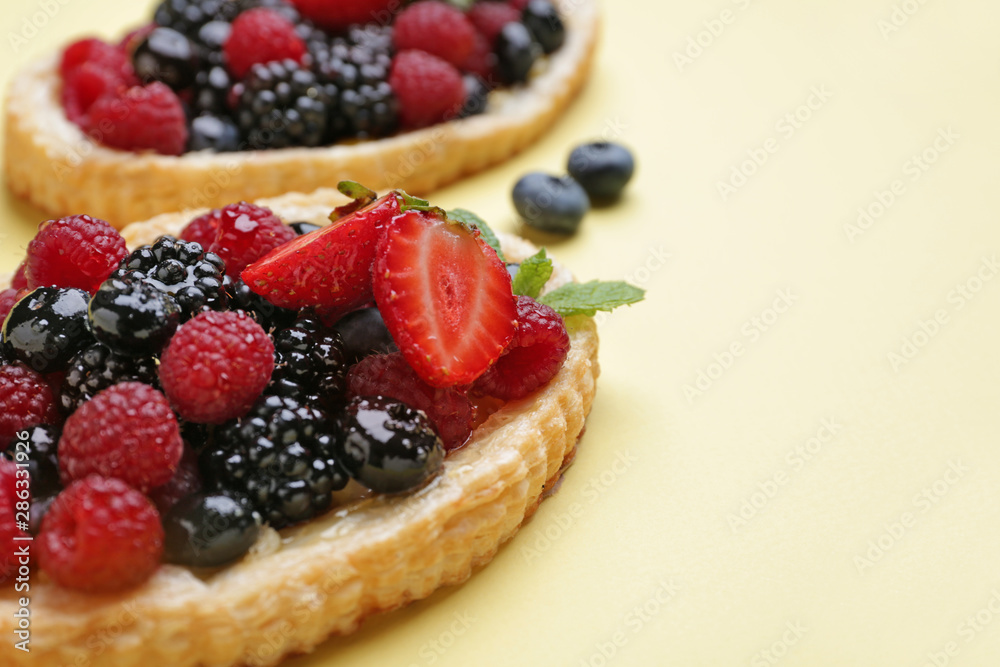 Sweet tartlet with berries on color background