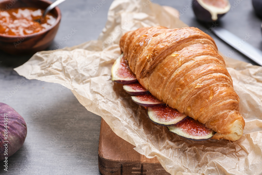 Sweet croissant and fig fruit slices on table, closeup