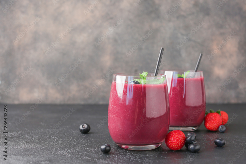 Glasses of acai smoothie on dark table