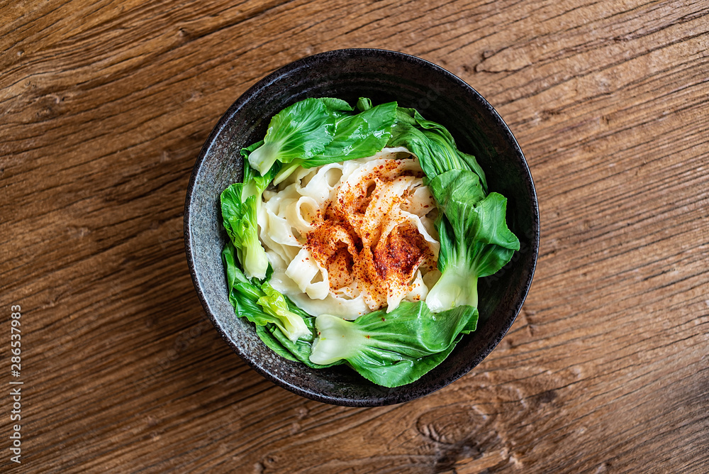 A bowl of nutritious and delicious oily noodles on a wooden tabletop