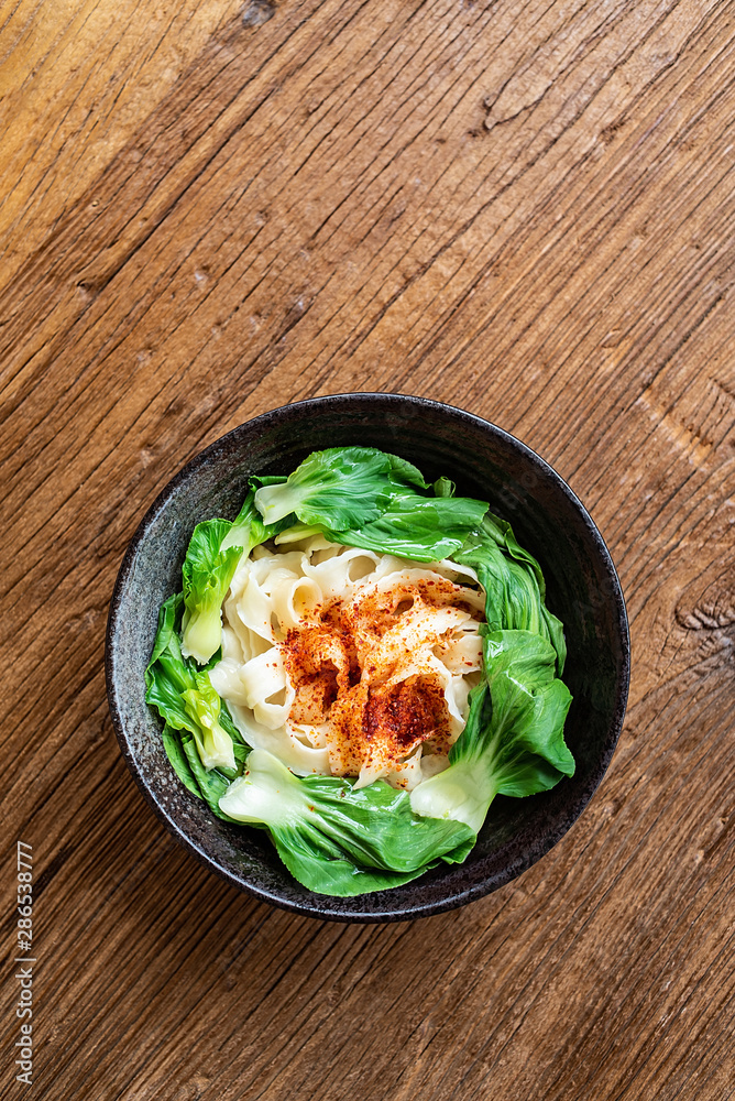 A bowl of nutritious and delicious oily noodles on a wooden tabletop