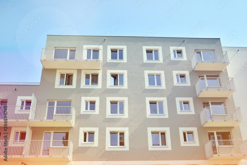 Modern apartment building detail, glass surface with sunlight