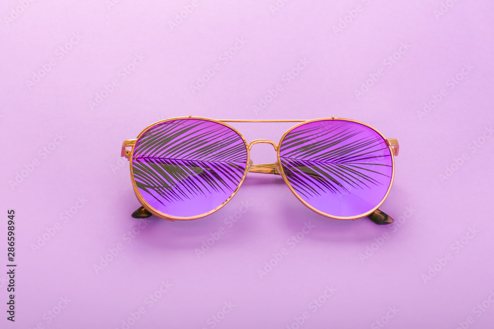 Stylish sunglasses on color background