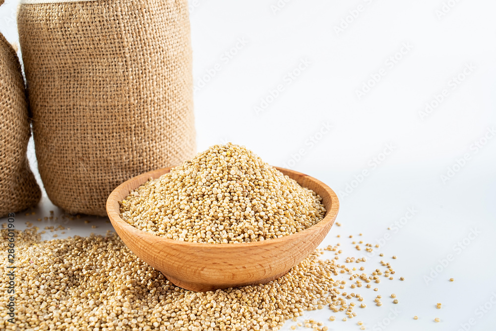 Sacks filled with grain and a bowl of buckwheat on a white background