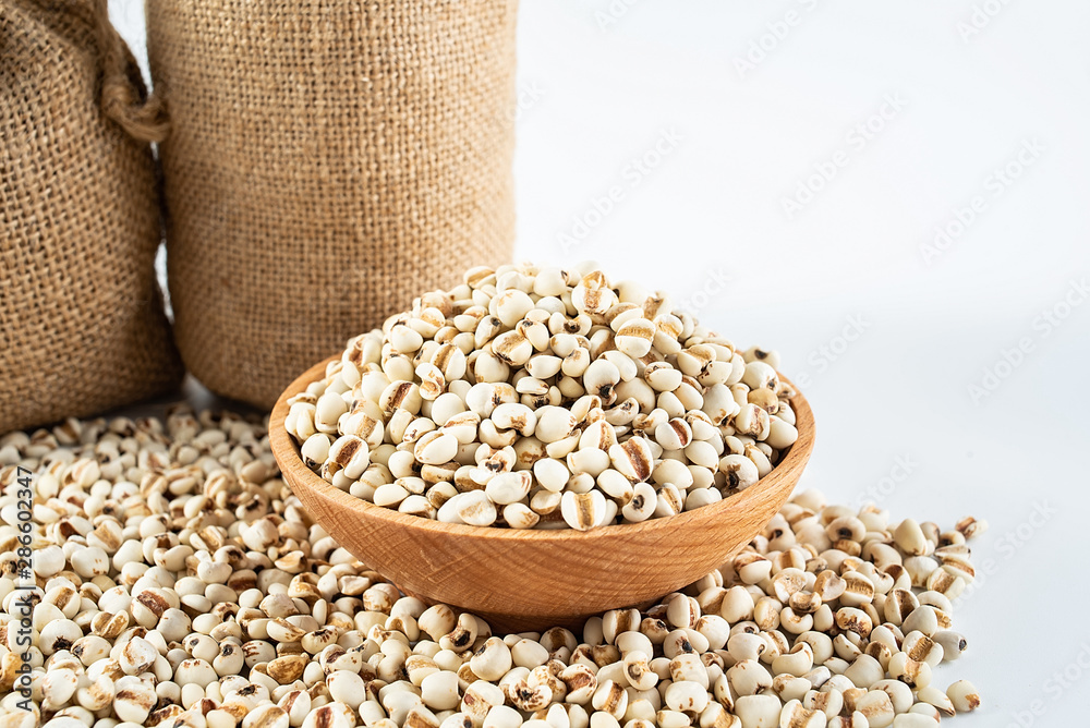 Sacks filled with grain and a bowl of glutinous rice on a white background