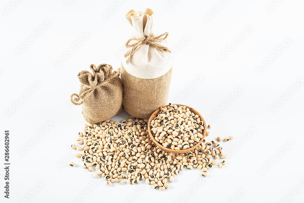 Sacks filled with grain and a bowl of rice beans on a white background