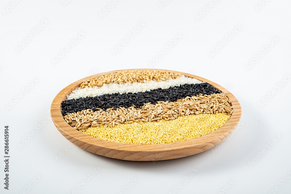 a wooden dish filled with whole grains cereal grain on a white background