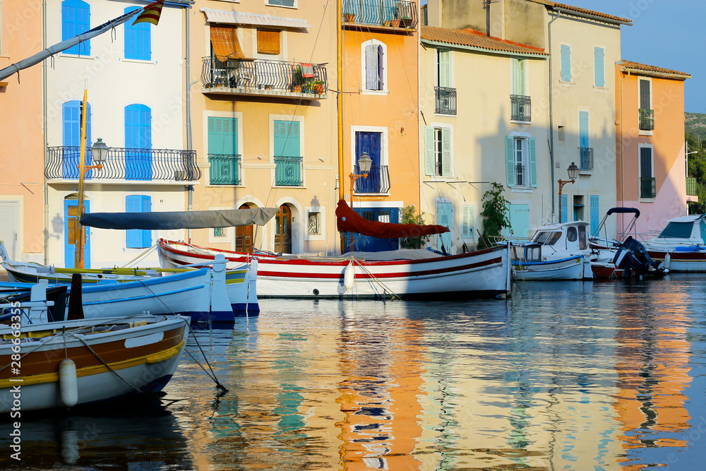  facade of mediterranean building with colorful shutter with river and boat