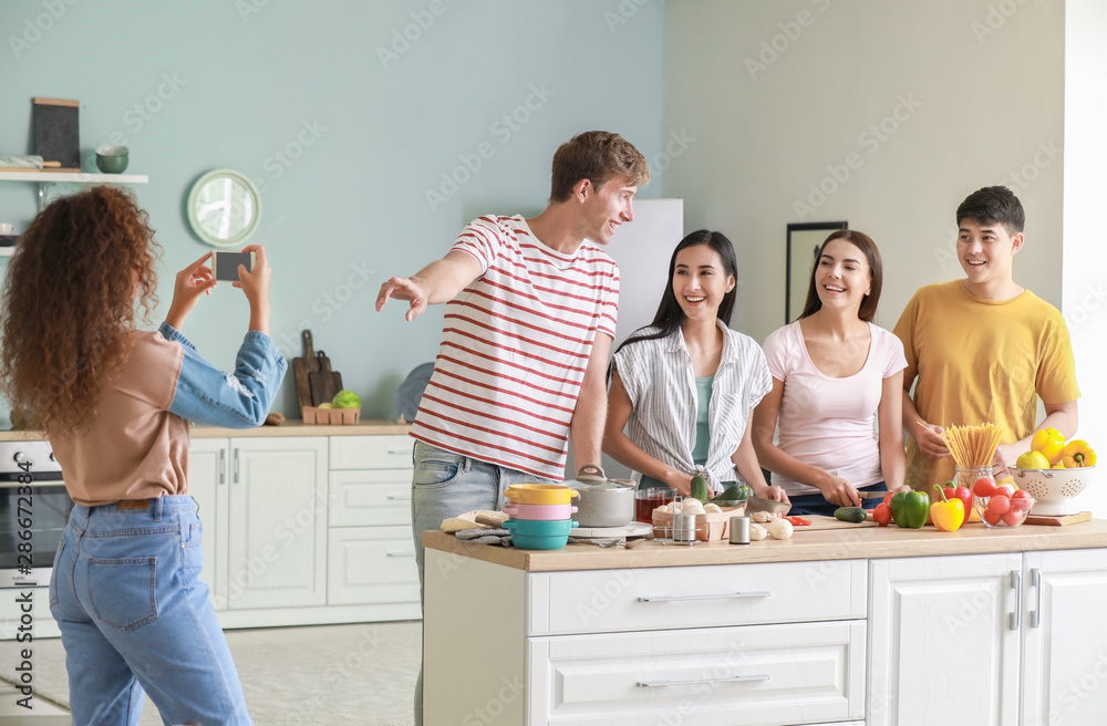 非裔美国妇女在厨房里给朋友做饭拍照