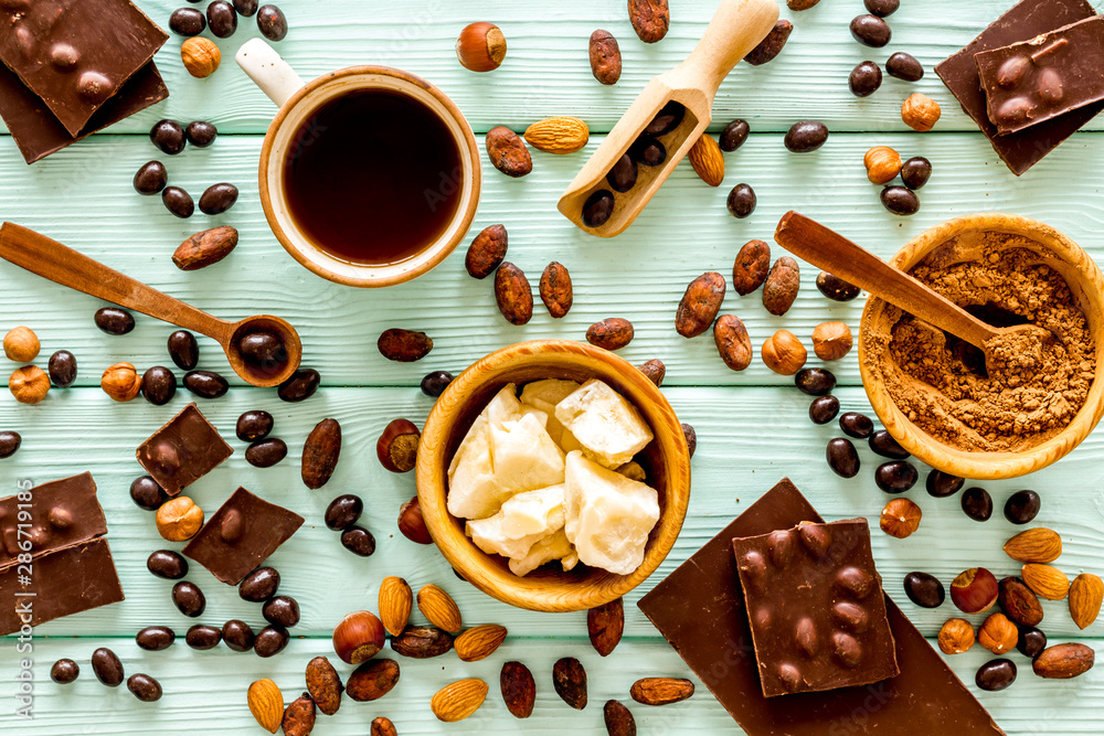 Different variety of chocolate and hazelnut on mint green wooden background top view