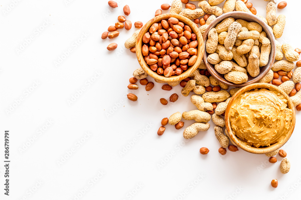 Make peanut butter with paste in glass bowl on white background top view copyspace