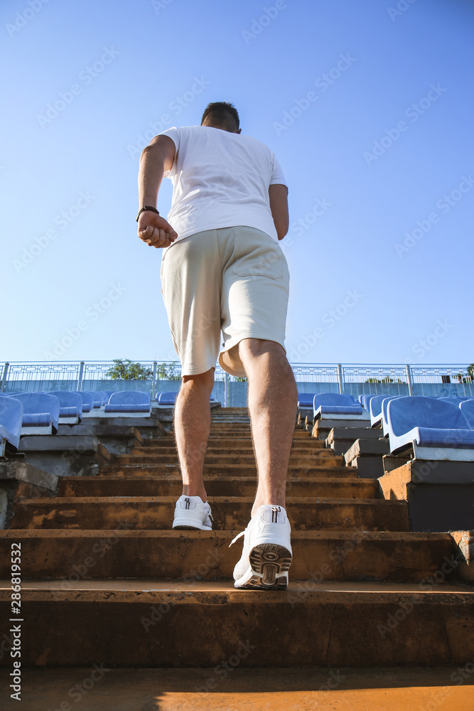 Sporty man running at the stadium