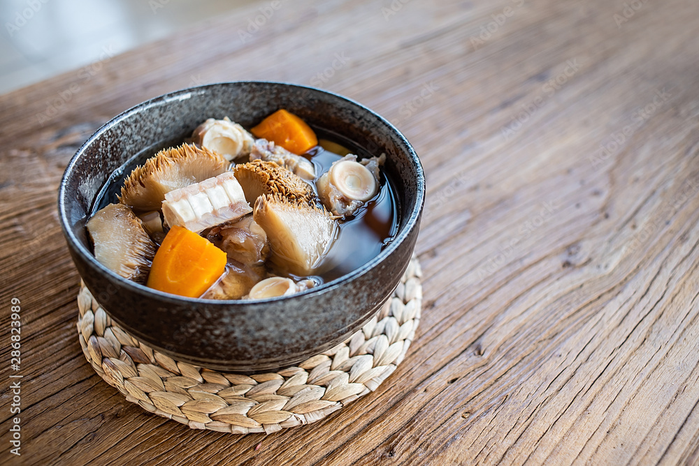 A bowl of Hericium erinaceus shark bone soup on a wooden table