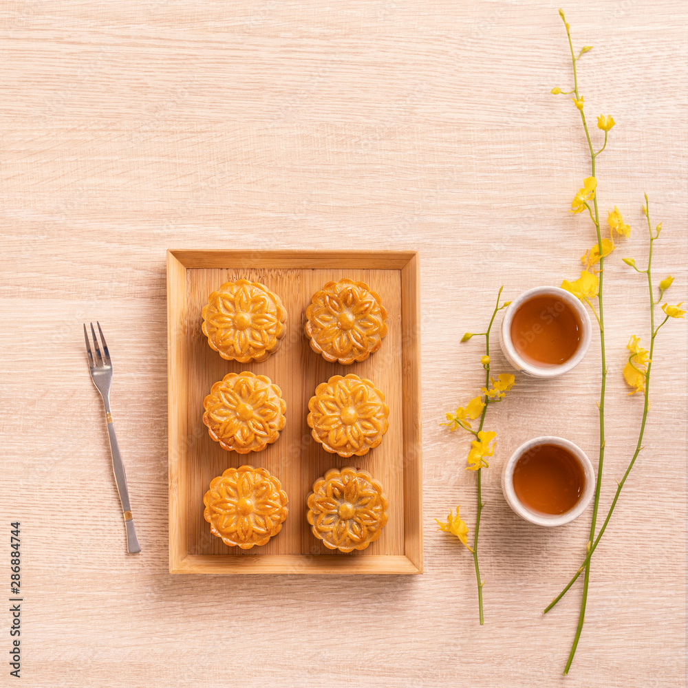 Moon cakes with tea on bright wooden table, holiday concept of Mid-Autumn festival traditional food 