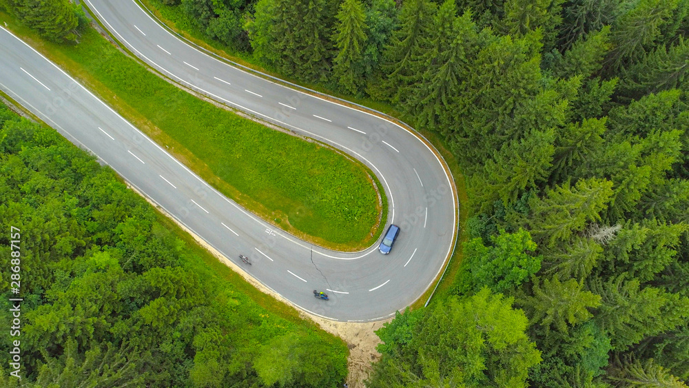 空中交通：摩托车和汽车在起伏的道路上通过发夹弯