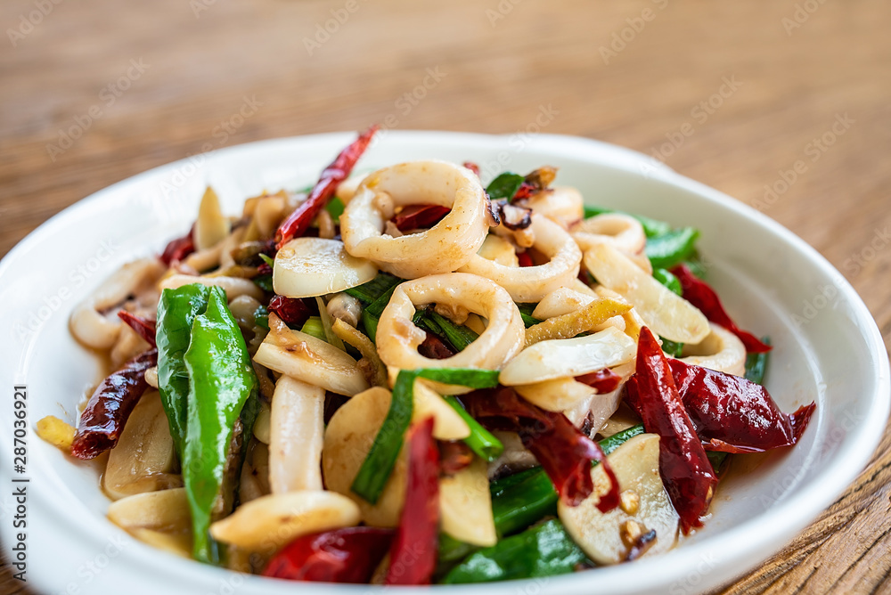 Chinese dish, a plate of spicy red shrimps on a wooden table