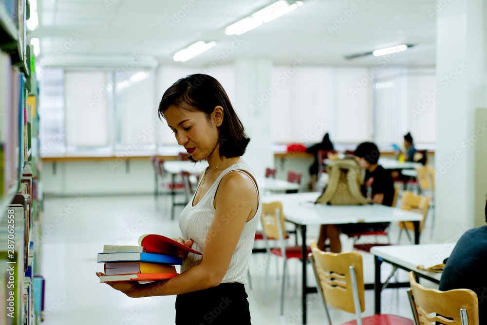 Asian  woman looking for a book on bookshelf at  bookstore , Relaxing lifestyle  healthy education c