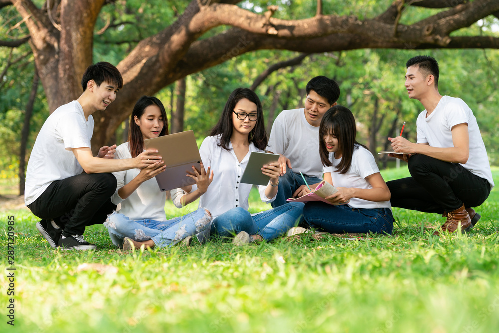 在大学或学校公园的小组项目中学习的年轻学生团队。快乐学习