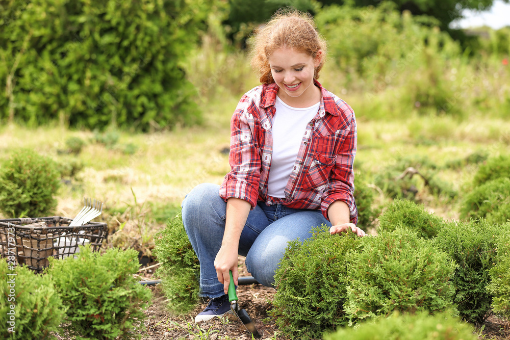 Female gardener taking care of plants outdoors