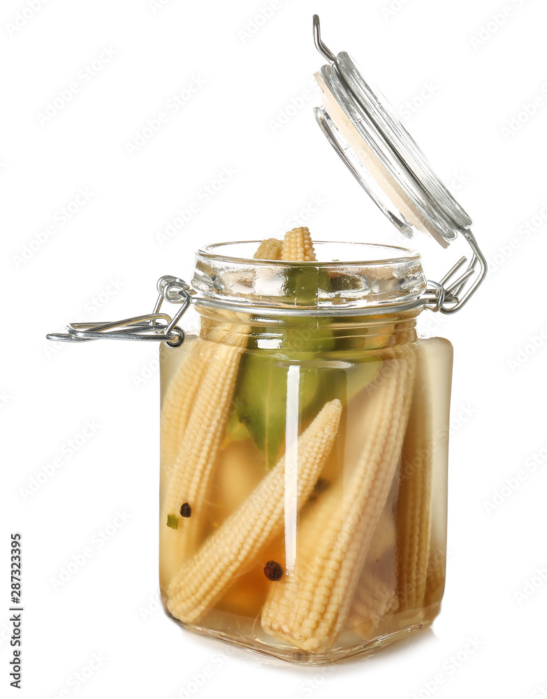 Jar with canned corn cobs on white background