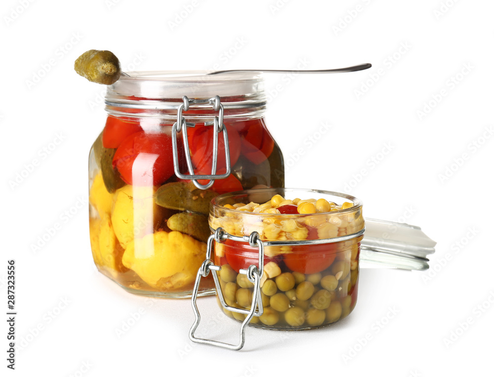 Jars with canned vegetables on white background