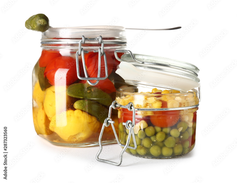 Jars with canned vegetables on white background