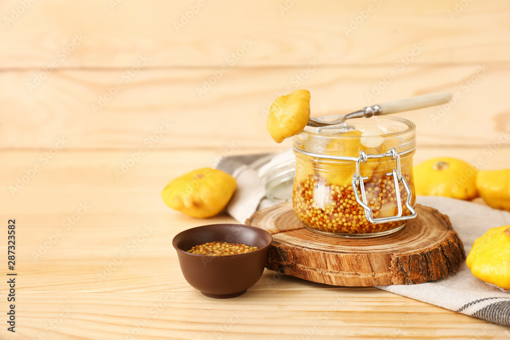 Jar with canned squashes on wooden table