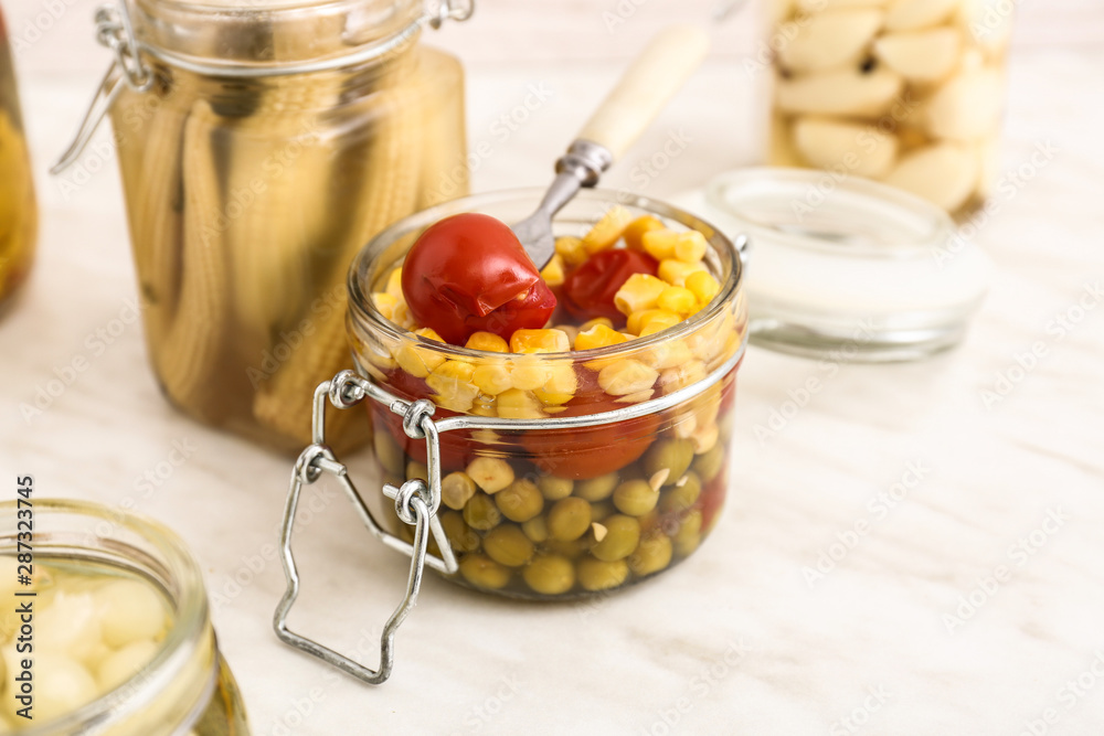 Jar with canned vegetables on light table