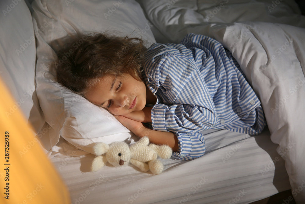 Cute little girl sleeping in bed at night