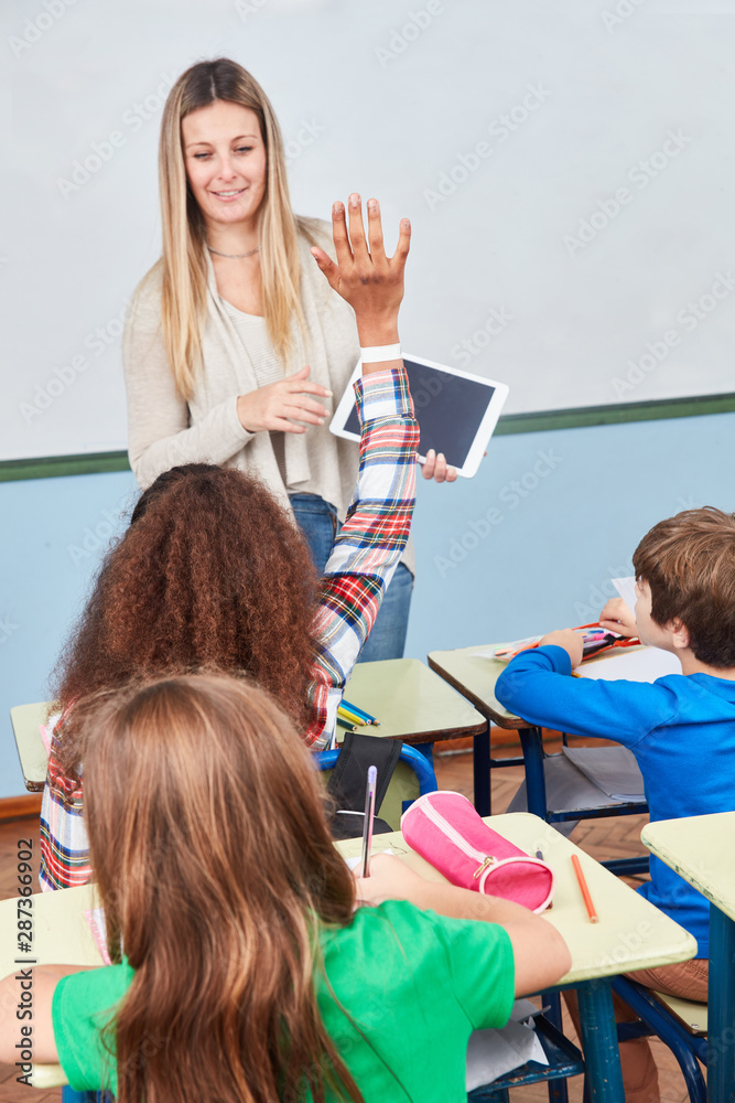 Schülerin hebt die Hand im Unterricht