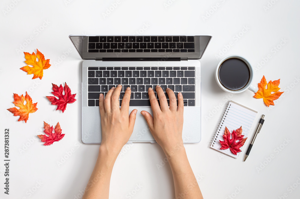 Autumn leaves with person using a laptop computer