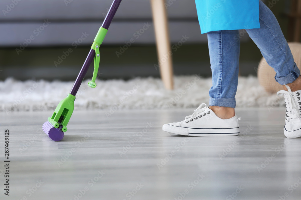 Woman mopping floor in room