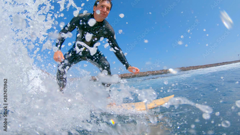 LOW ANGLE, UNDERWATER: Young surfer riding a fast barrel wave in sunny Lobos.