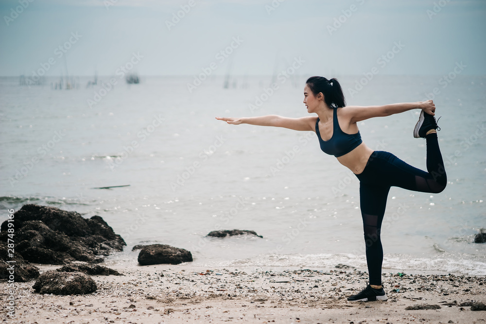 一个美丽的亚洲女人在早上跑步喝水。锻炼和户外运动