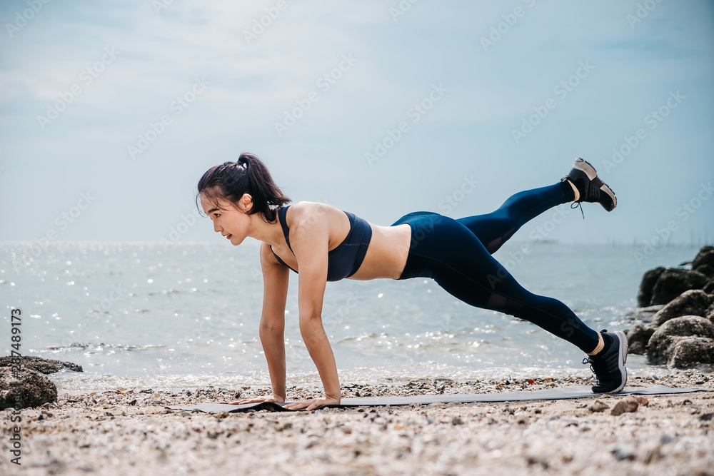 一个美丽的亚洲女人在早上跑步和喝水。锻炼和户外运动。