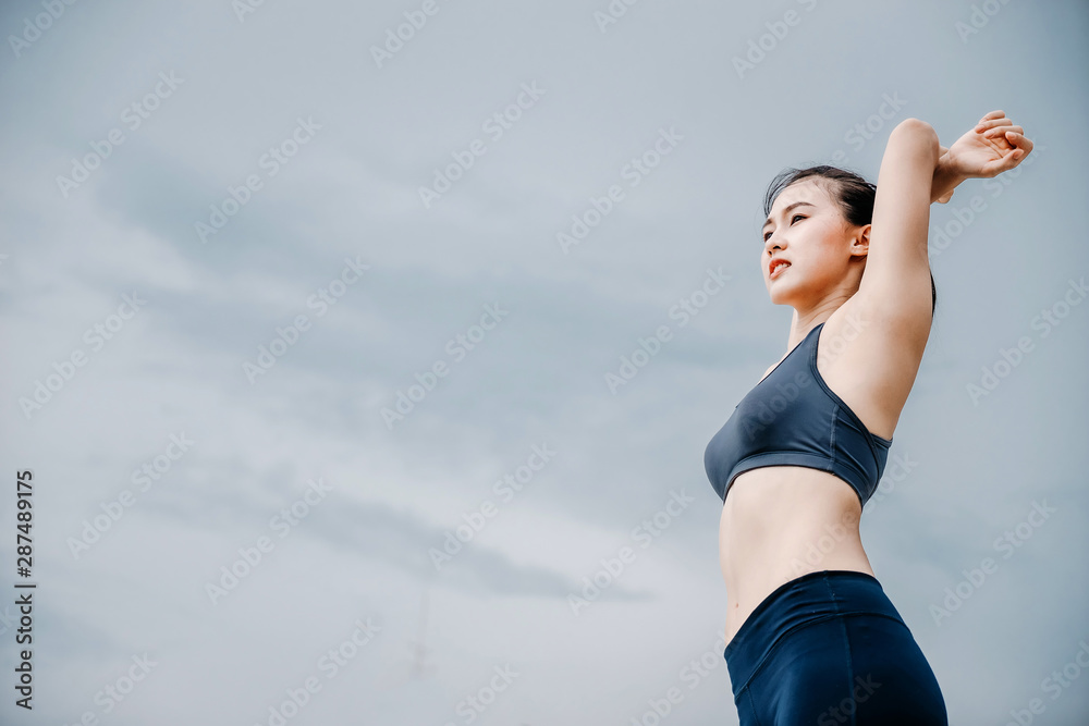 一个美丽的亚洲女人在早上跑步喝水。锻炼和户外运动