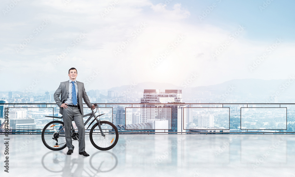 Happy man standing on balcony with bike