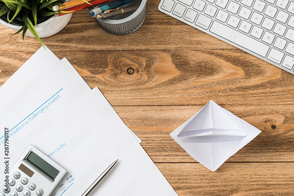 Wooden office desk with white origami boat.