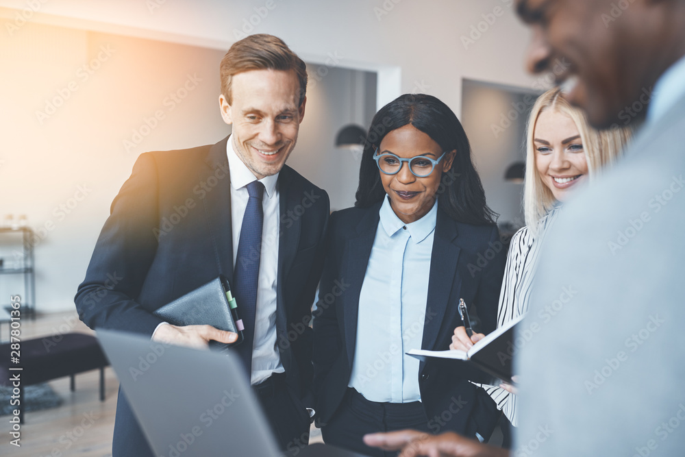 Smiling businesspeople working on a laptop in an office