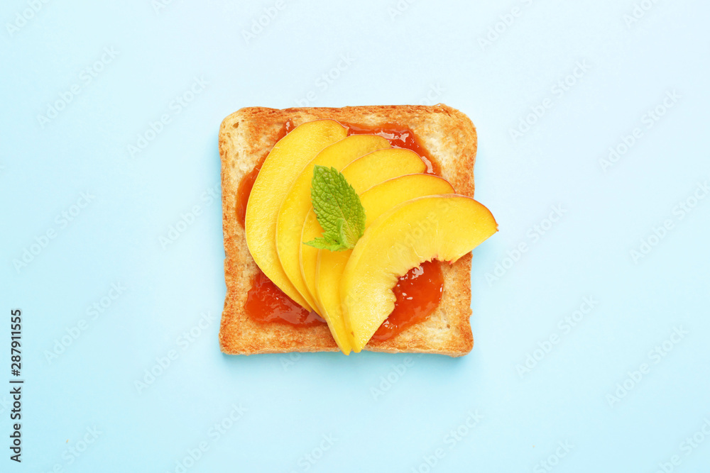 Tasty toasted bread with fruit jam on color background