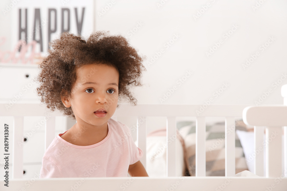 Little African-American girl sitting in bed