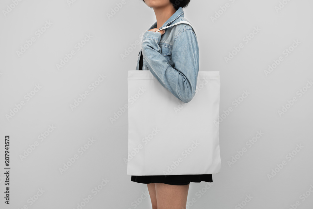 young woman holding eco cotton bag isolate on white background