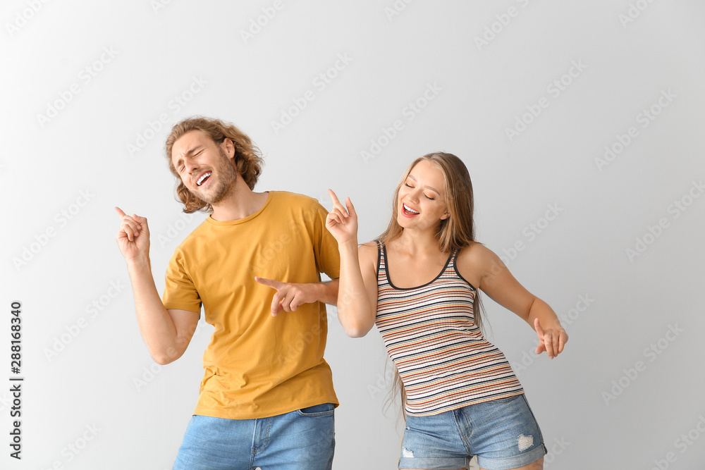 Cool young couple dancing against white background