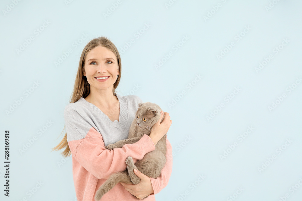 美丽的女人和可爱的猫在彩色背景上